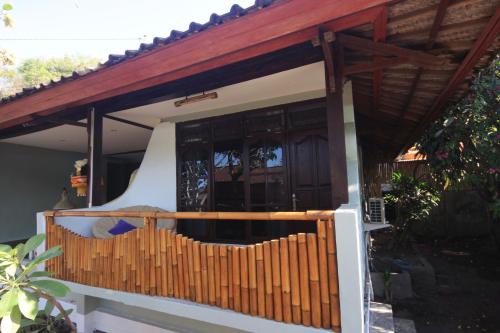 a porch of a house with a wooden fence at Bamboo Paradise in Padangbai