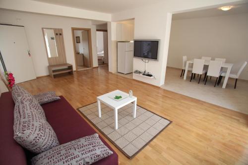 a living room with a couch and a table at Villa Iris Apartments in Seget Vranjica