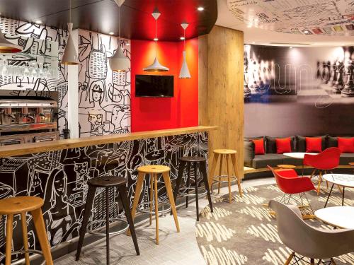 a restaurant with a bar with chairs and tables at Ibis Sfax in Sfax
