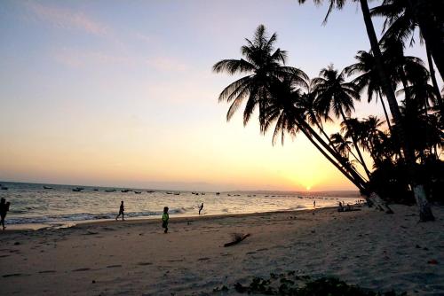 a group of people on the beach at sunset at Ngoc Sang Guesthouse in Mui Ne