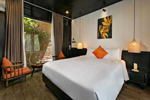 a bedroom with a large white bed and a window at MAI Villa Da Nang in Danang