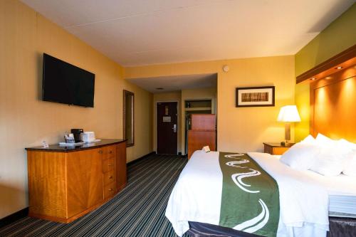 a hotel room with a bed and a flat screen tv at Quality Inn Cromwell - Middletown in Cromwell