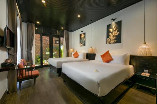 a bedroom with two beds and a table and a chair at MAI Villa Da Nang in Da Nang