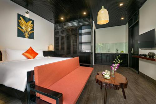 a bedroom with a large bed and a table at MAI Villa Da Nang in Da Nang
