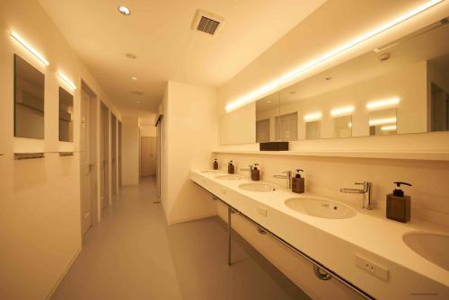 a bathroom with two sinks and a large mirror at Book And Bed Tokyo Shinjuku in Tokyo