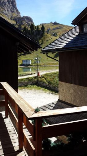 a wooden bench on a porch of a building at Hotel Garni Gonzaga in Canazei