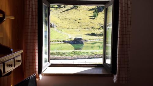 a window in a room with a view of a field at Hotel Garni Gonzaga in Canazei