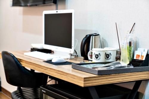 a desk with a computer on top of it at Siheung Seoul Tourist Hotel in Siheung