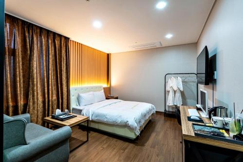 a hotel room with a bed and a couch at Siheung Seoul Tourist Hotel in Siheung