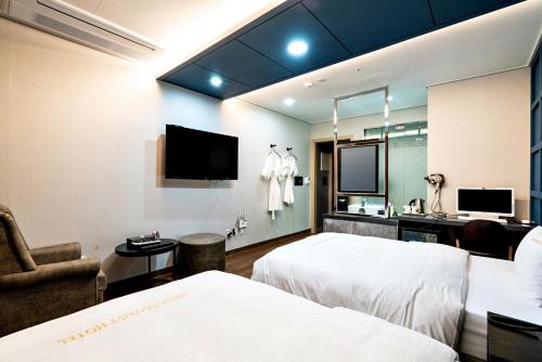 a hotel room with two beds and a mirror at Siheung Seoul Tourist Hotel in Siheung
