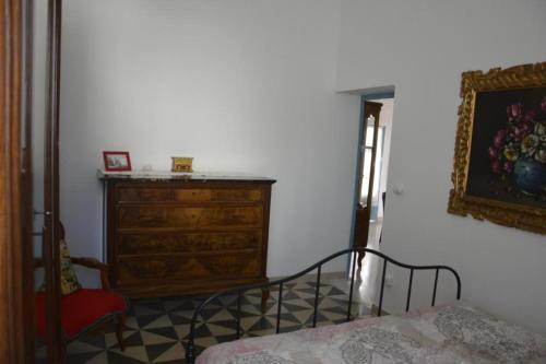 a bedroom with a wooden dresser and a bed at Appartamento in palazzina storica / Oberdan Suites in Alberobello
