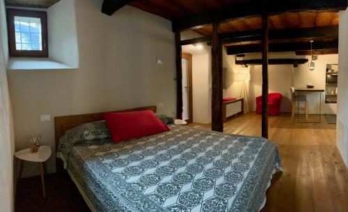 ein Schlafzimmer mit einem Bett mit einem roten Kissen darauf in der Unterkunft Casa Pietra in Trontano