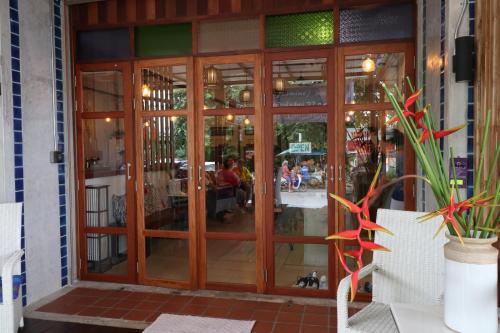 una puerta de cristal a un restaurante con gente de fondo en Little Jasmine by the River, en Phitsanulok