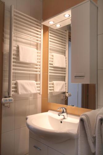 a bathroom with a sink and a mirror and towels at Villa Iris Apartments in Seget Vranjica