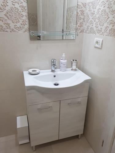 a bathroom with a white sink and a mirror at Luxury Studio Anis 1 in Mamaia Sat/Năvodari