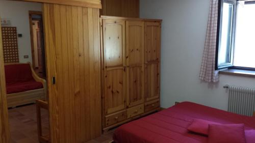 a bedroom with a wooden cabinet and a bed at Hotel Garni Gonzaga in Canazei