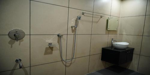 a bathroom with a shower and a sink in it at Nextel Inn, Calicut in Kozhikode