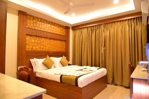 une chambre avec un lit et une fenêtre avec des rideaux dans l'établissement Hotel White Boutique, à Pondichéry