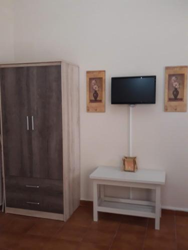 uma sala de estar com um armário e uma televisão em Kefallonia Bay Resort em Spartia