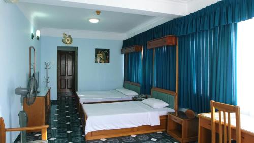 two beds in a room with blue walls at Hoa Tieu Guesthouse in Vung Tau