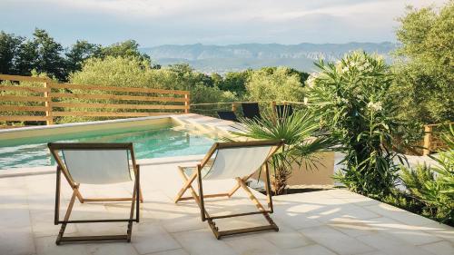 2 sedie sedute su un patio accanto alla piscina di Four Bedrooms Villa Anita a Polje