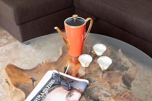 a table with a book and a cup and glasses on it at Varkiza by the sea in Vari