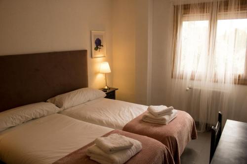 a hotel room with two beds with towels on them at El Sueño del Infante in Guadalajara