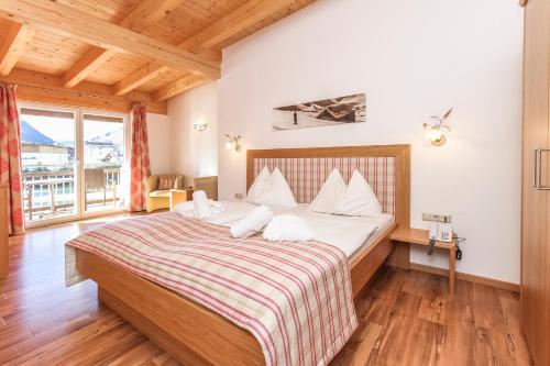 a bedroom with a large bed with white pillows at Hotel Tannenberg in Saalbach Hinterglemm