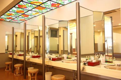 a bathroom with a row of sinks with mirrors at Hotel Towadaso in Towada