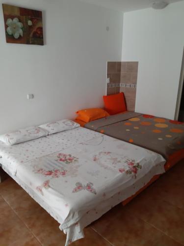 two beds in a room with a bedspread with flowers at VASILIJA, studio apartman in Budva