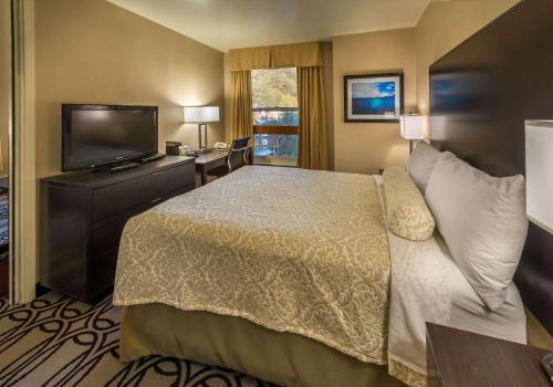 a hotel room with a bed and a flat screen tv at Baranof Downtown, BW Signature Collection in Juneau