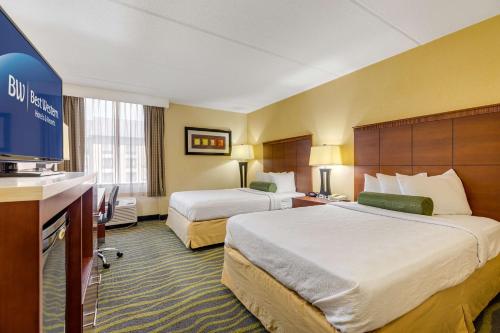 シャーロットにあるBest Western Plus Charlotte Matthews Hotelのベッド2台とテレビが備わるホテルルームです。
