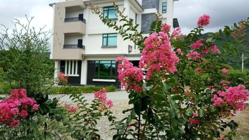a house with pink flowers in front of it at Hua Lian Sin Su Homestay in Zhixue