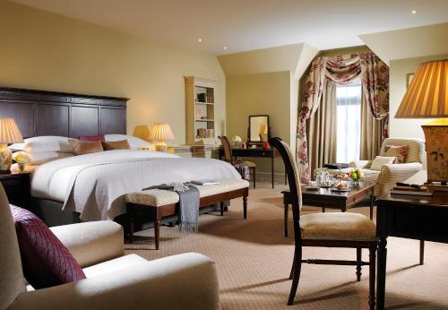 1 dormitorio con 1 cama grande y sala de estar en Knockranny House Hotel & Spa, en Westport