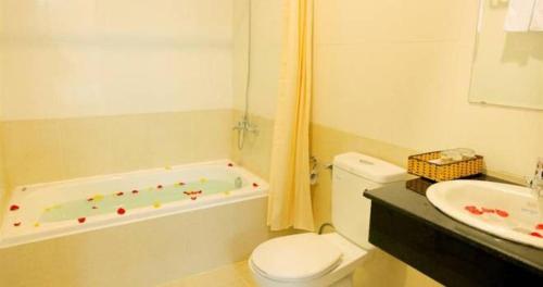 a bathroom with a tub and a toilet and a sink at Hoa Tieu Guesthouse in Vung Tau