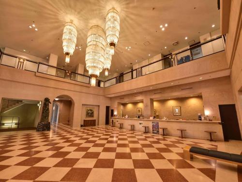 a large lobby with a checkered floor and chandeliers at Yugashima Golf Club & Hotel Resort in Izu