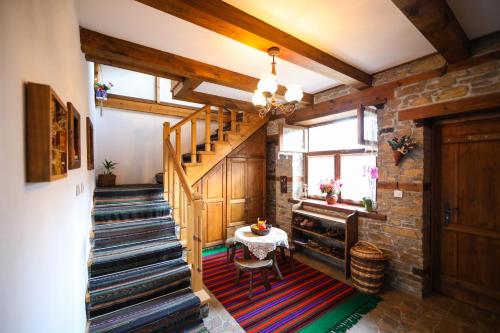 a staircase in a room with a table on a rug at Тодорината къща in Leshten