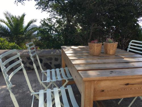 a wooden table with two chairs and two plants on it at Alonia Studios in Firostefani