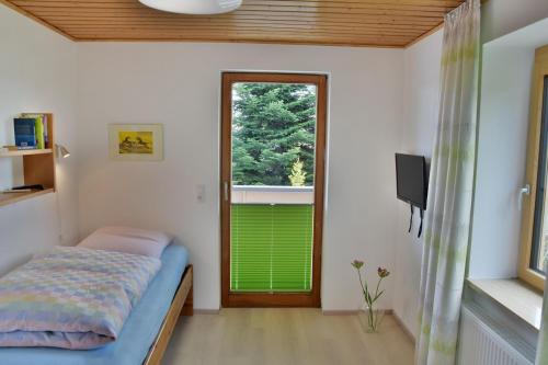 Habitación con cama, ventana y TV. en Ferienwohnung Close en Lindenberg im Allgäu