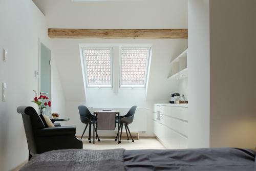 a bedroom with a table and two chairs and a bed at Alte Apotheke - Studio Appartements Karlsbad in Karlsbad