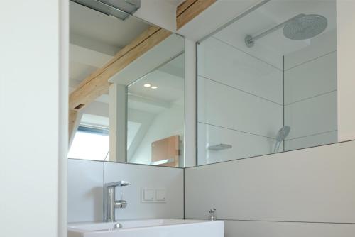 a bathroom with a sink and a mirror at Alte Apotheke - Studio Appartements Karlsbad in Karlsbad