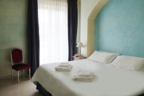 a bedroom with a large white bed with a window at Hotel Terme Eden in Abano Terme