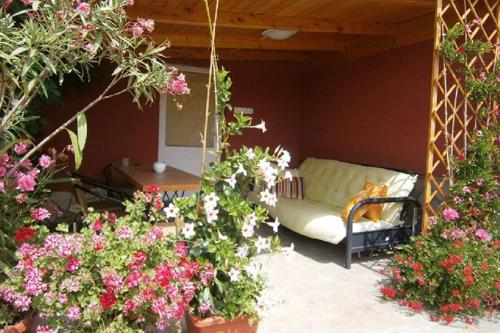 a porch with a swing and some flowers at Papp Apartmanház in Vonyarcvashegy