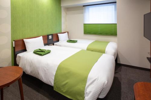 two beds in a room with green and white at Kitanoniwa The Kuretakeso in Hamamatsu