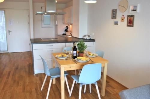 une cuisine avec une table en bois et des chaises bleues dans l'établissement Apartment Seerhein, à Constance