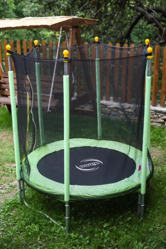 a small trampoline in the grass in a yard at Тодорината къща in Leshten