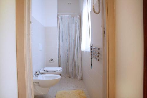 a white bathroom with a toilet and a sink at Hotel Lagomaggio in Rimini