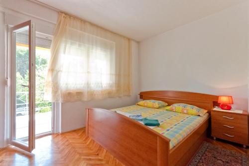 a bedroom with a bed and a window at Apartments Jerković in Stari Grad