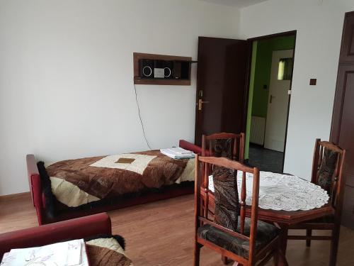 a bedroom with a bed and a table and chairs at Agroturystyka u Zbyszka in Tylmanowa
