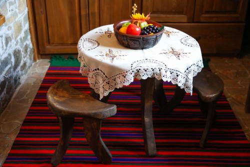 a table with a bowl of fruit on it at Тодорината къща in Leshten